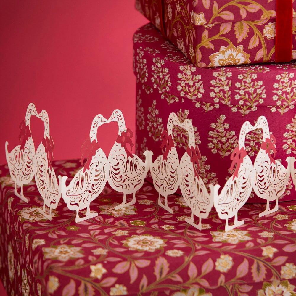 Gänsegirlande von Bungalow auf roten Geschenkschachteln